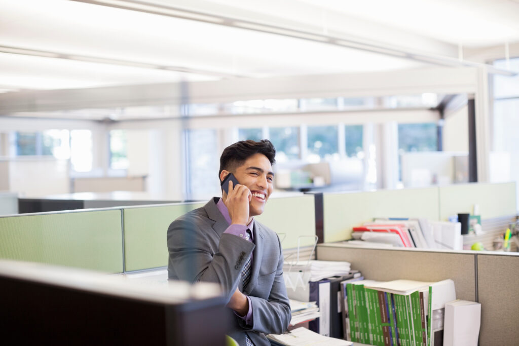 Image of a businessman having a friendly phone chat in an office. American Mortgage Processing Services.